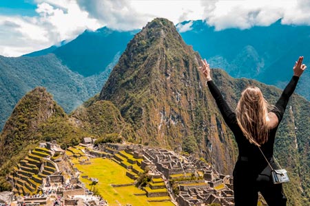 Turistas levantando la mano frente a Machu Picchu