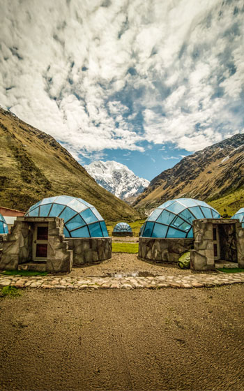 Vista del exclusivo Campamento Sky Camp, con sus domos de lujo y la majestuosa Montaña Salkantay en el fondo.