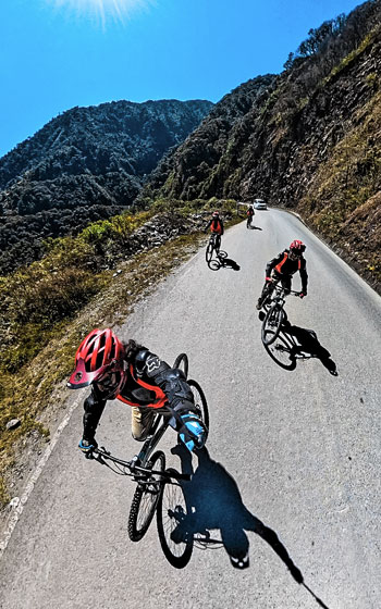 Grupo de turistas en bicicleta disfrutando del emocionante descenso en el Inca Jungle Trail, con destino a Machu Picchu.