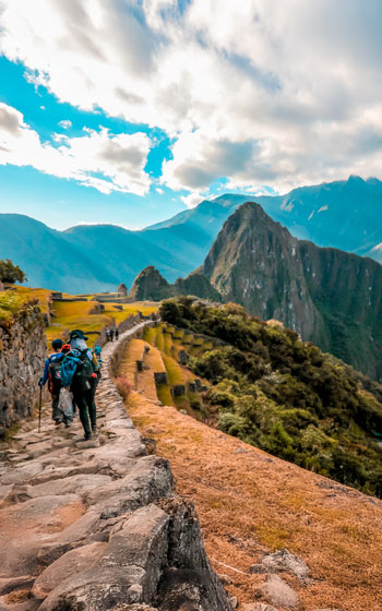 Grupo de turistas caminando por el sendero en dirección al sitio arqueológico de Machu Picchu.