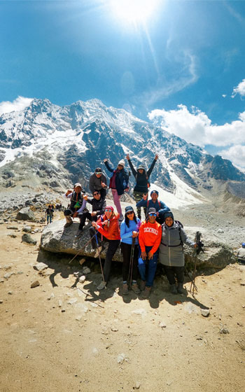 Grupo de turistas felices y sonrientes celebrando en el Paso Salkantay, la cumbre del famoso Salkantay Trek.