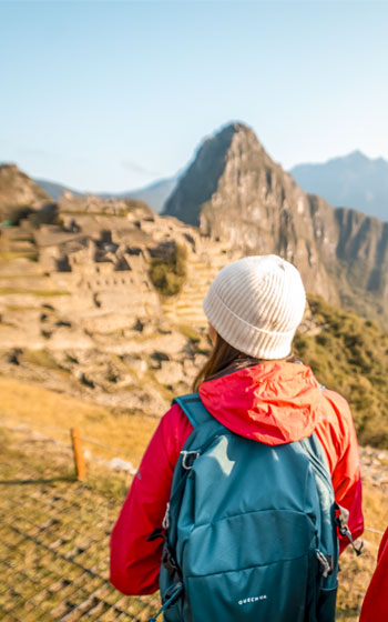 Grupo de turistas recorriendo la ciudadela inca de Machu Picchu, explorando sus antiguas construcciones y el majestuoso paisaje andino que la rodea.
