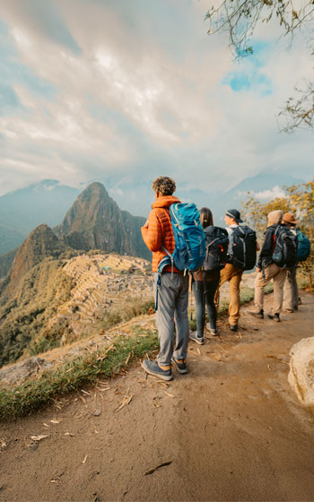 Grupo de turistas observando y admirando la majestuosa Ciudadela Inca de Machu Picchu desde el mirador principal.