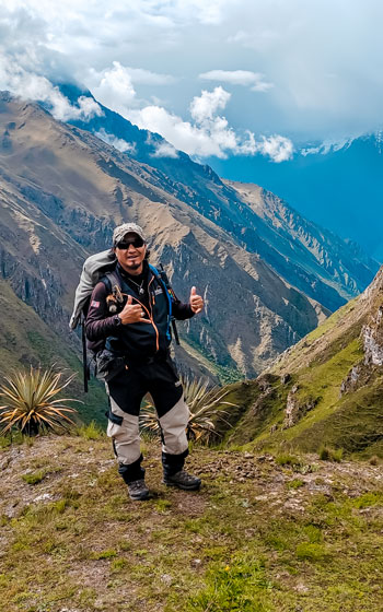 Guía turístico en la ruta de Ancascocha, rodeado de un impresionante paisaje montañoso y la asombrosa belleza natural de los Andes peruanos.