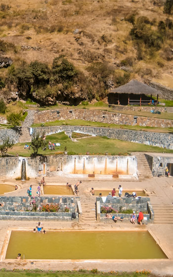 Vista panorámica de los Baños Termales de Lares, rodeados por las tranquilas montañas y el exuberante paisaje del Valle Sagrado de Perú.
