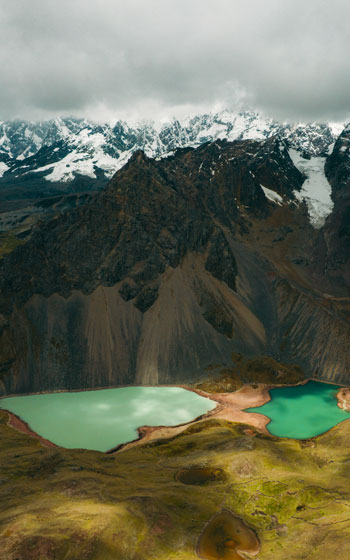 Vista panorámica de dos lagunas turquesas al pie de la gran Cordillera Ausangate. Aguas de color vibrante en el paisaje de alta montaña de Perú.