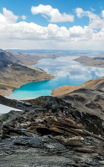 Foto panorámica de la gran Laguna Sibinacocha en los Andes. Extenso paisaje de alta montaña con aguas turquesas y cumbres nevadas en Perú.