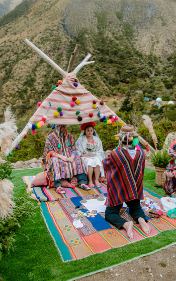 Pareja de turistas celebrando su boda andina tradicional en una ceremonia oficiada por un chamán andino.