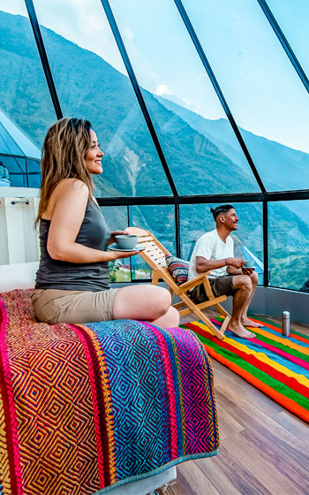 Pareja de turistas disfrutando de la comodidad interior de un domo de lujo en el Campamento Mountain Sky View.