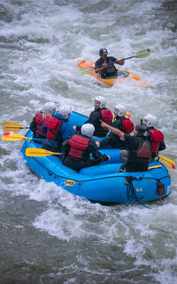 Grupo de turistas en una emocionante aventura de rafting en la Ruta Inca Jungle, rodeados por el paisaje tropical andino.