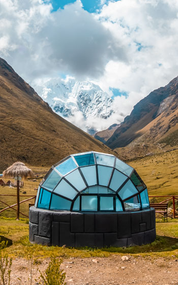 Campamento de glamping Sky Camp en la Ruta Salkantay, con la majestuosa montaña nevada Salkantay de fondo.