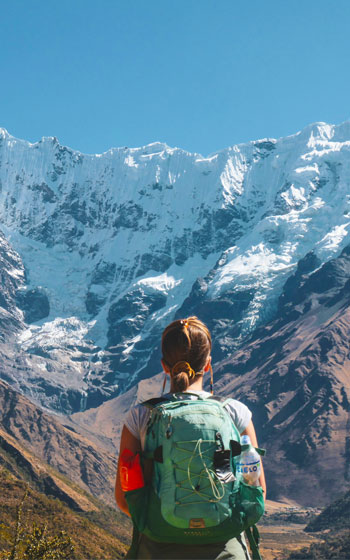 Turista contemplando la impresionante montaña Humantay, un popular destino de trekking en Perú.
