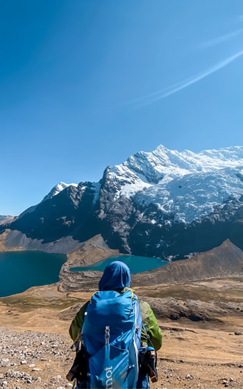 Turista en primer plano contemplando la majestuosidad del gran Nevado Ausangate. Senderismo en los Andes de Perú con vistas espectaculares.