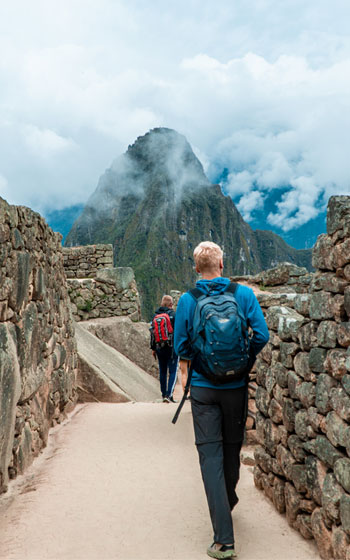 Turista observando la imponente Ciudadela Inca de Machu Picchu durante su recorrido por las ruinas.