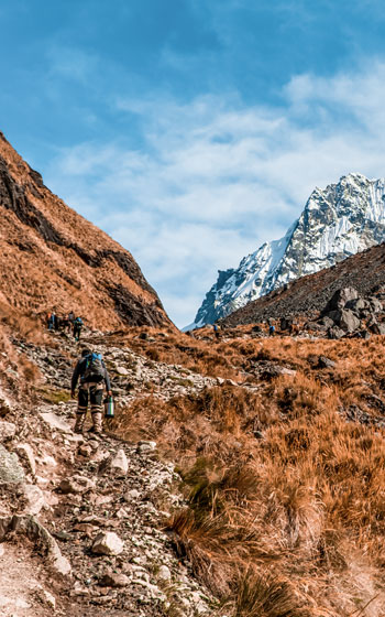 Turista haciendo trekking en la Ruta Salkantay, caminando hacia el punto más alto, el Paso Salkantay.