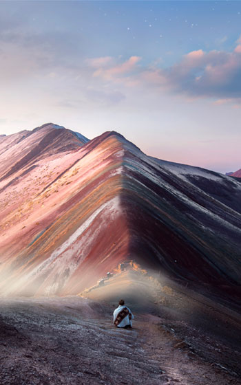 Turistas observando el espectacular amanecer en la cima de la Montaña Arcoíris (Vinicunca), una experiencia única en los Andes de Perú.