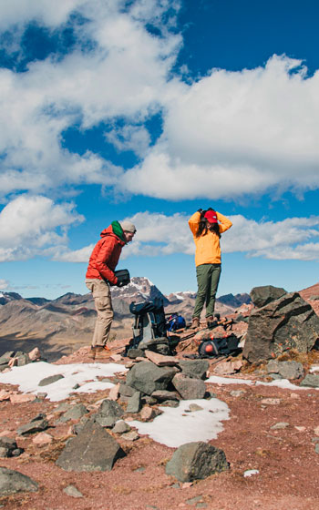 Turistas descansando durante la caminata hacia la gran Laguna Sibinacocha. Mochileros en la ruta de trekking de alta montaña en Perú.