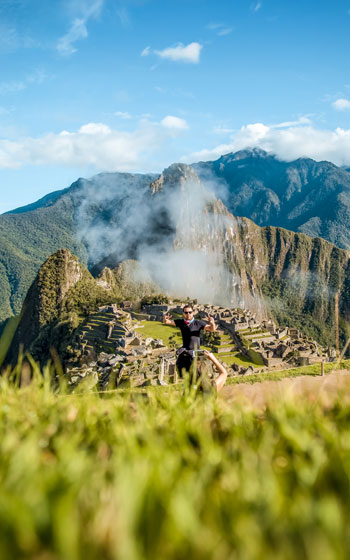 Grupo de turistas disfrutando de la experiencia y las vistas de la majestuosa ciudadela Inca de Machu Picchu.
