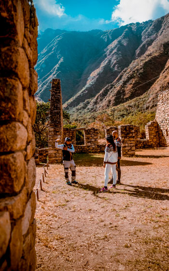 Guía turístico y grupo de turistas en el sitio arqueológico de Chachabamba, un punto importante en la ruta del Camino Inca.