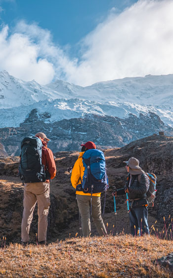 Grupo de turistas admirando la vista del Nevado Ausangate en Perú. Experiencia de trekking andino y paisaje de alta montaña.