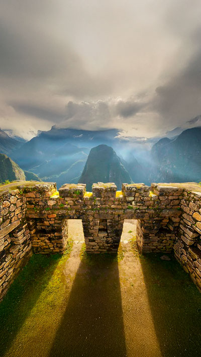 Arquitectura y construcciones incas de Machu Picchu con la majestuosa montaña Putucusi de fondo, mostrando la ingeniería ancestral y los impresionantes paisajes de los Andes peruanos.