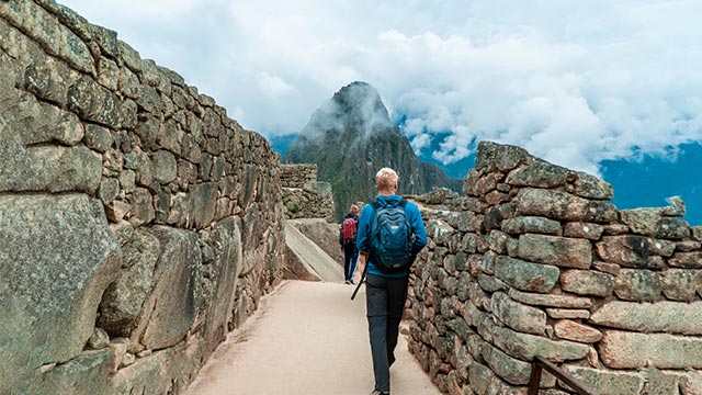Turistas recorriendo el sitio arqueológico de Machu Picchu, explorando sus impresionantes construcciones incas y disfrutando de los majestuosos paisajes andinos.