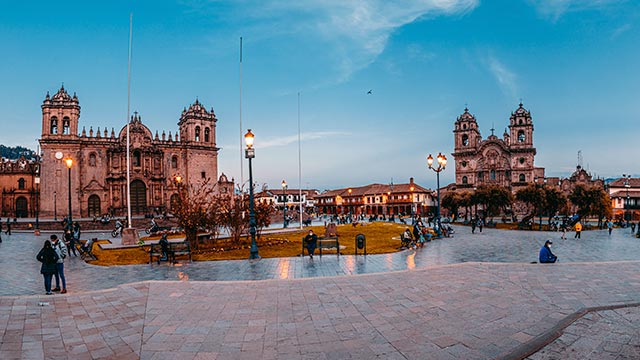 Pareja de turistas en la Plaza de Armas del Cusco, la plaza principal de la ciudad, disfrutando de su arquitectura colonial e historia.