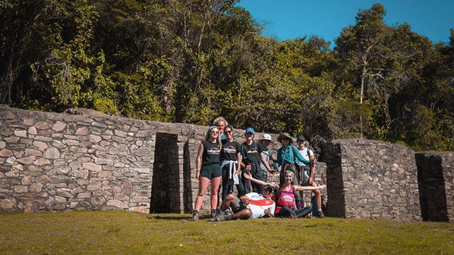 Grupo de viajeros visitando el Sitio Arqueológico Inca de Llactapata rodeado de mucha vegetación durante el viaje en la ruta del Inca Jungle