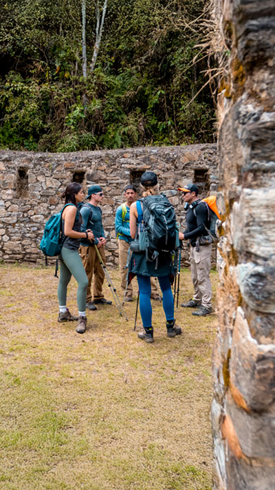 Grupo de viajeros visitando el Sitio Arqueológico Inca de Llactapata rodeado de mucha vegetación durante el viaje en la ruta del Inca Jungle