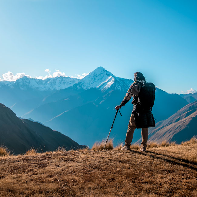 Turistas contemplando las montañas andinas cubiertas de nieve a lo largo de la ruta Ancascocha, rodeados de majestuosos paisajes altoandinos.