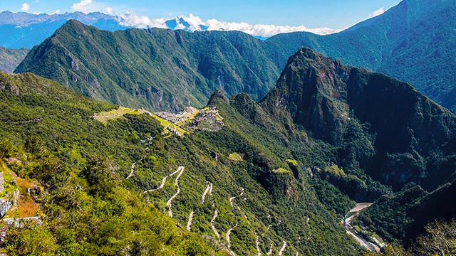 Vista panorámica del Santuario de Machu Picchu desde la Puerta del Sol (Inti Punku), mostrando la majestuosidad de la ciudadela inca y los impresionantes paisajes andinos que la rodean.