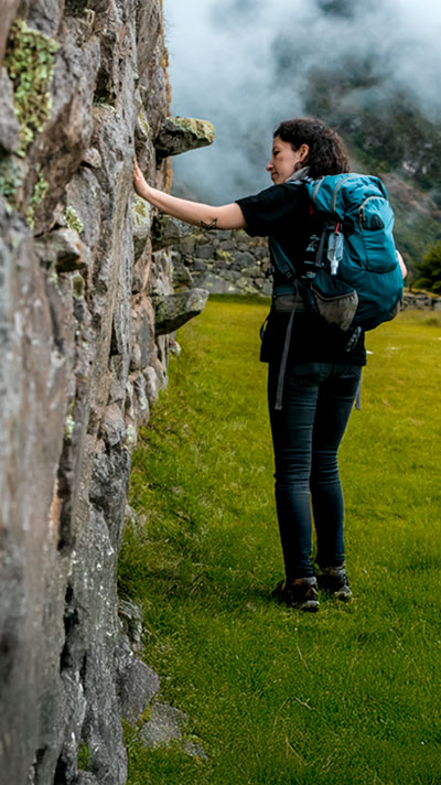 Turista admirando una maravillosa construcción inca durante un tour en Cusco, explorando la rica herencia cultural y los impresionantes paisajes andinos del Perú.