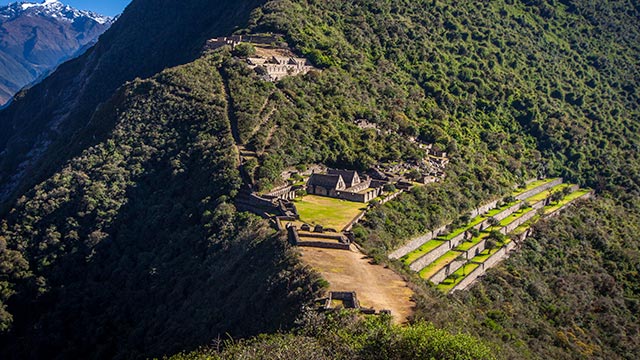 Vista panorámica de la gran ciudadela inca de Choquequirao, conocida como la hermana de Machu Picchu, rodeada de majestuosos paisajes andinos y destacando su impresionante arquitectura ancestral.
