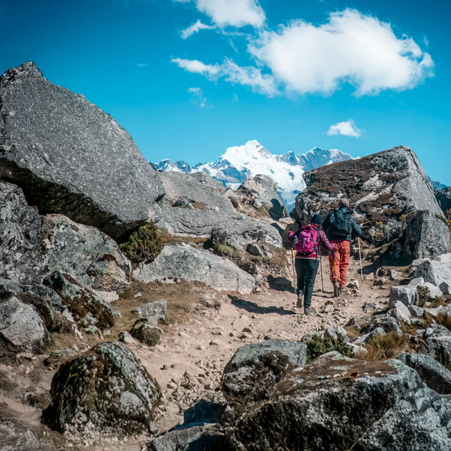 Grupo de turistas realizando la desafiante caminata a la montaña sagrada de Salkantay y Machu Picchu, disfrutando de paisajes espectaculares y la majestuosidad de los Andes peruanos.