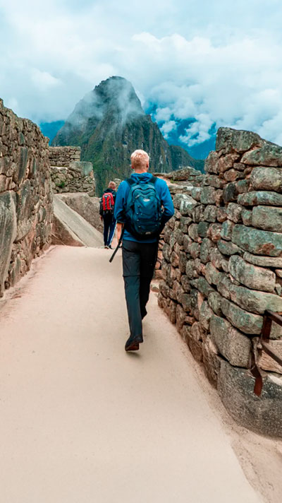 Turistas recorriendo el sitio arqueológico de Machu Picchu, explorando sus impresionantes construcciones incas y disfrutando de los majestuosos paisajes andinos.