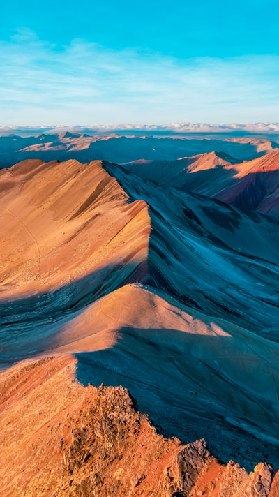 Vista aérea de la hermosa Montaña del Arcoíris (Vinicunca) en Perú, mostrando sus vibrantes colores naturales y el impresionante paisaje andino.