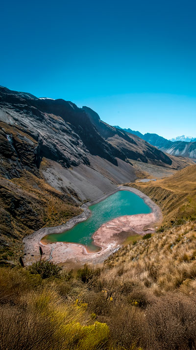 Vista panorámica del Glaciar Huayanay y la Laguna Ancascocha, rodeados de majestuosos paisajes altoandinos en los Andes peruanos.