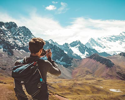 Joven tomando una foto de las cadenas montañosas y los glaciares de Perú