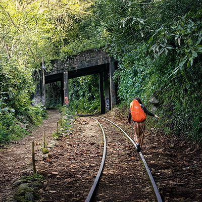 Excursionista caminando por el sendero junto a las vías del tren en el trayecto de Hidroeléctrica a Aguas Calientes, la etapa final de la caminata Salkantay.