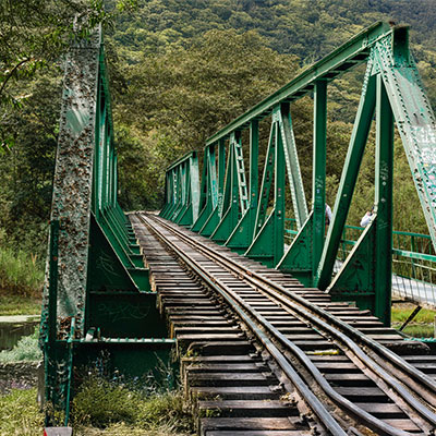 Puente de metal para excursionistas cruzando el caudaloso río Urubamba en la ruta de senderismo hacia Aguas Calientes, Machu Picchu.