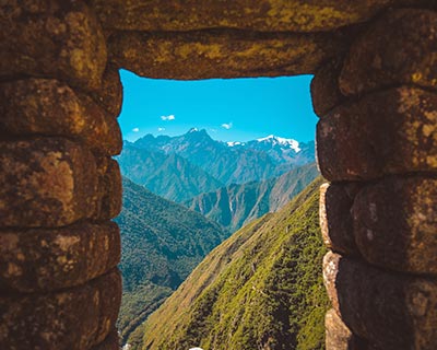Vista del paisaje a través de una ventana de piedra en Machu Picchu