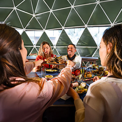 Grupo de turistas disfrutando de un almuerzo saludable y nutritivo en el comedor de madera del Super Jungle Lodge en la selva de Salkantay.