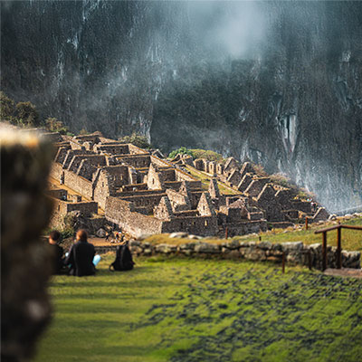 Vista detallada de los muros de piedra perfectamente encajados y las terrazas agrícolas (andenes) de la ciudadela inca de Machu Picchu en Cusco, Perú.