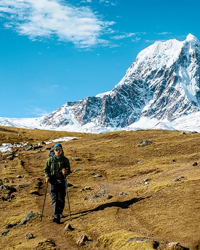 Turista caminando junto a la impresionante montaña Ausangate