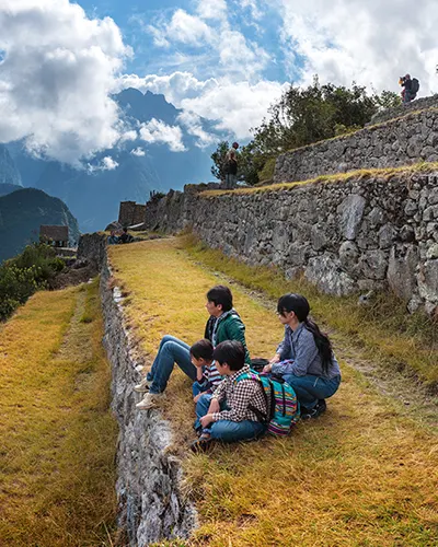 Una familia de visitantes en los andenes de Machu Picchu