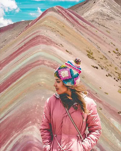 Turista disfrutando del viento de los Andes en la montaña arcoiris.