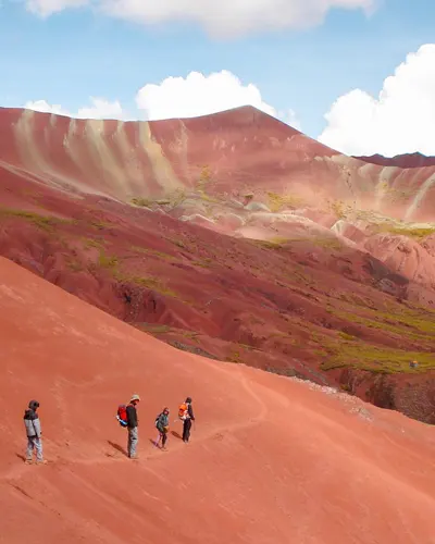 Turistas disfrutando en el valle rojo al lado de la montaña del arco iris